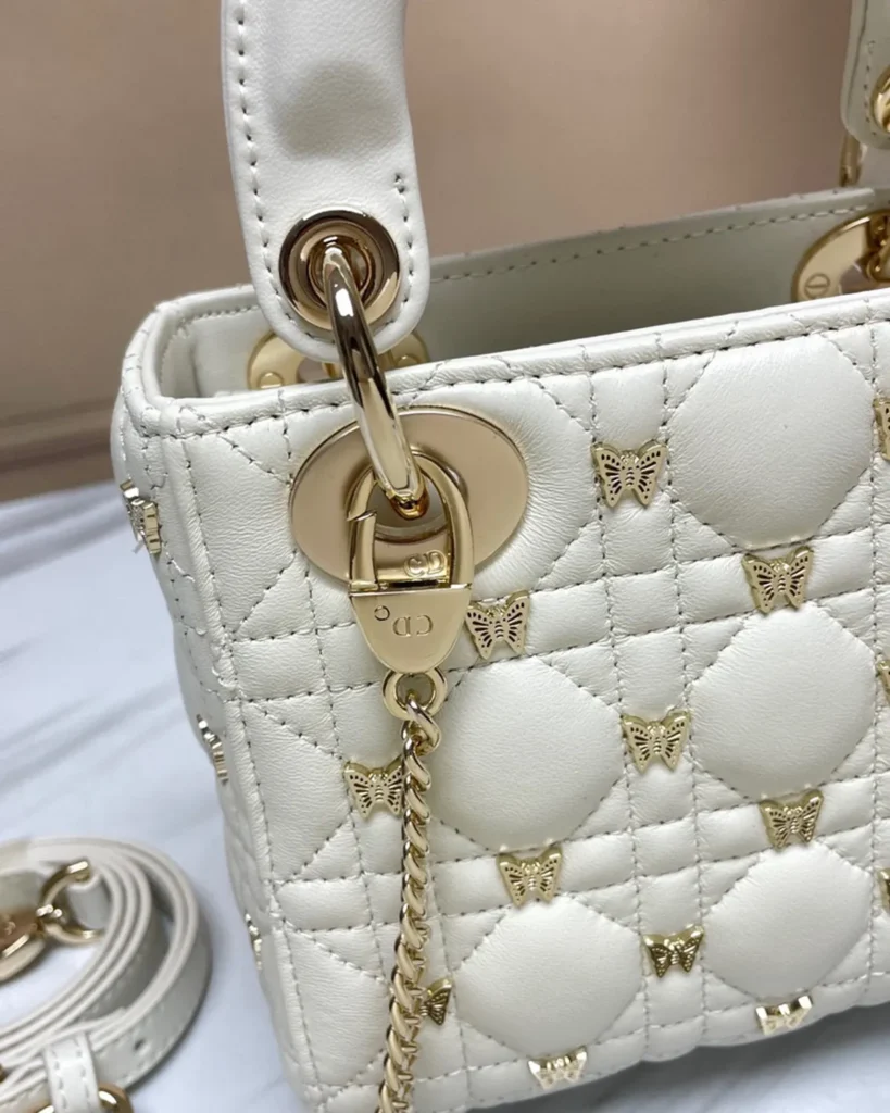 Ivory Butterfly Stud Quilted Top Handle Bag — chain detail view