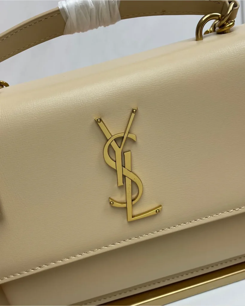 Cream Top-Handle Accordion Flap Bag — logo detail view