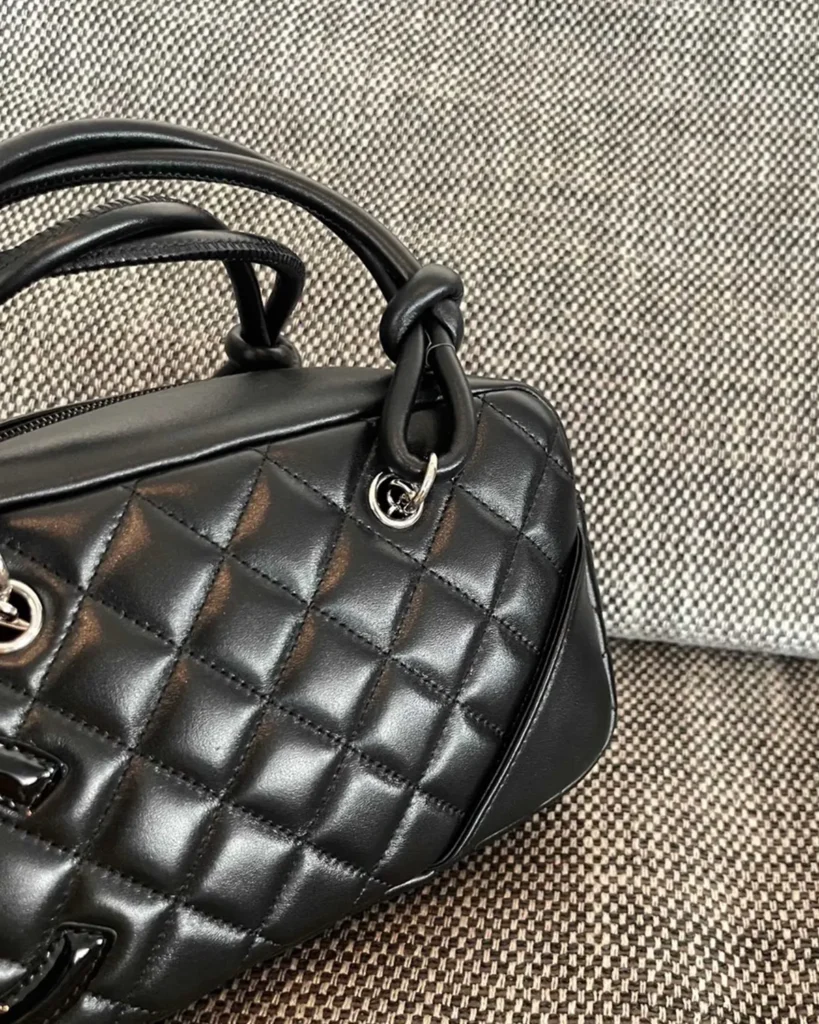 Black Quilted Offset-Emblem Bowler Bag — front detail view