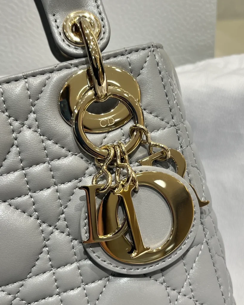 Pearlescent Gray Quilted Top Handle Bag — charm detail view