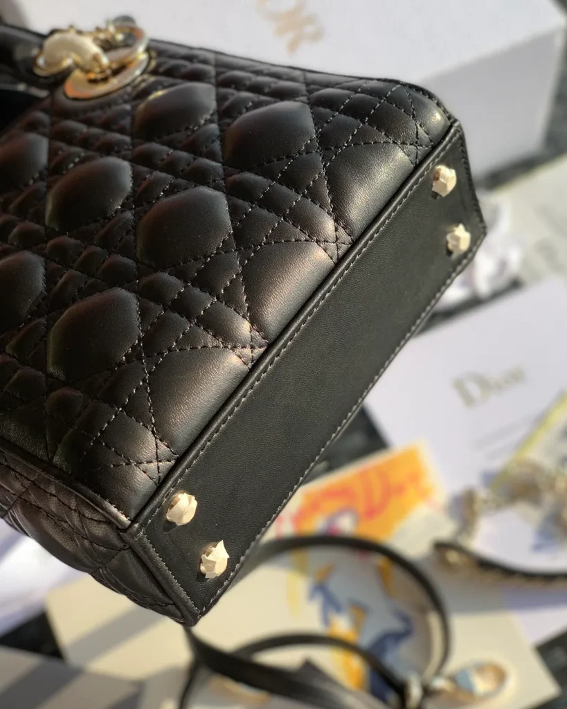 Black Quilted Compact Top Handle Bag — base detail view