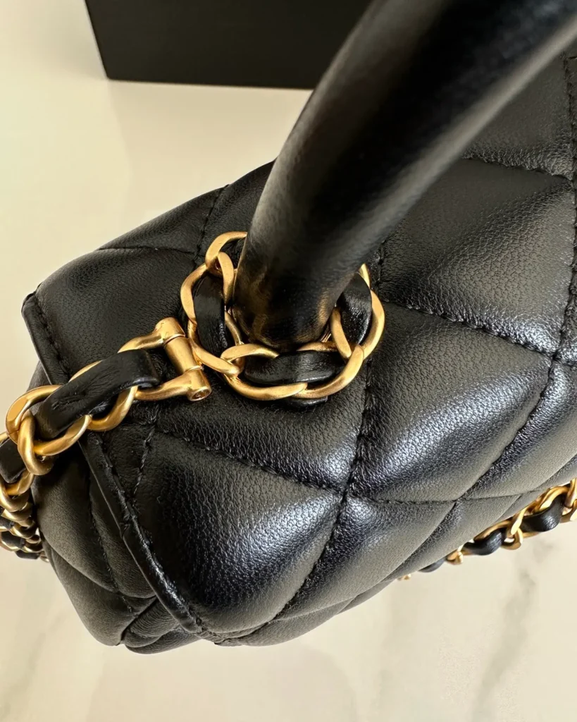 Black Rounded Quilted Top-Handle Bag — handle detail view