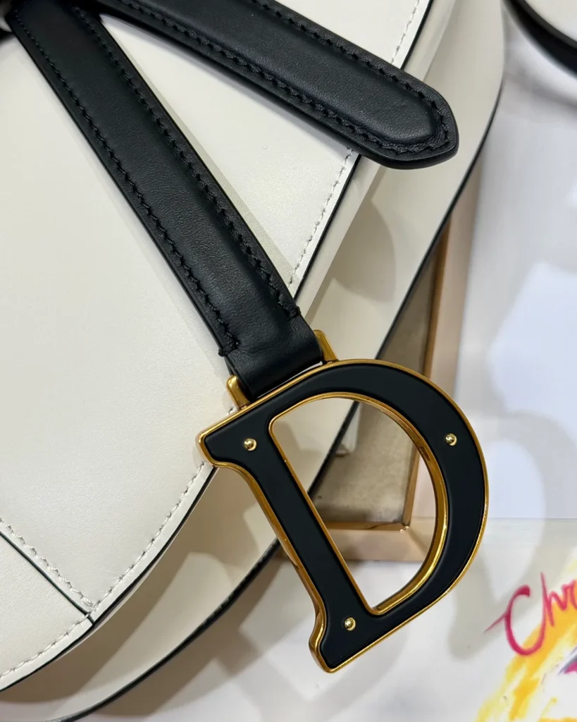 Cream and Black Asymmetric Saddle Bag — charm detail view