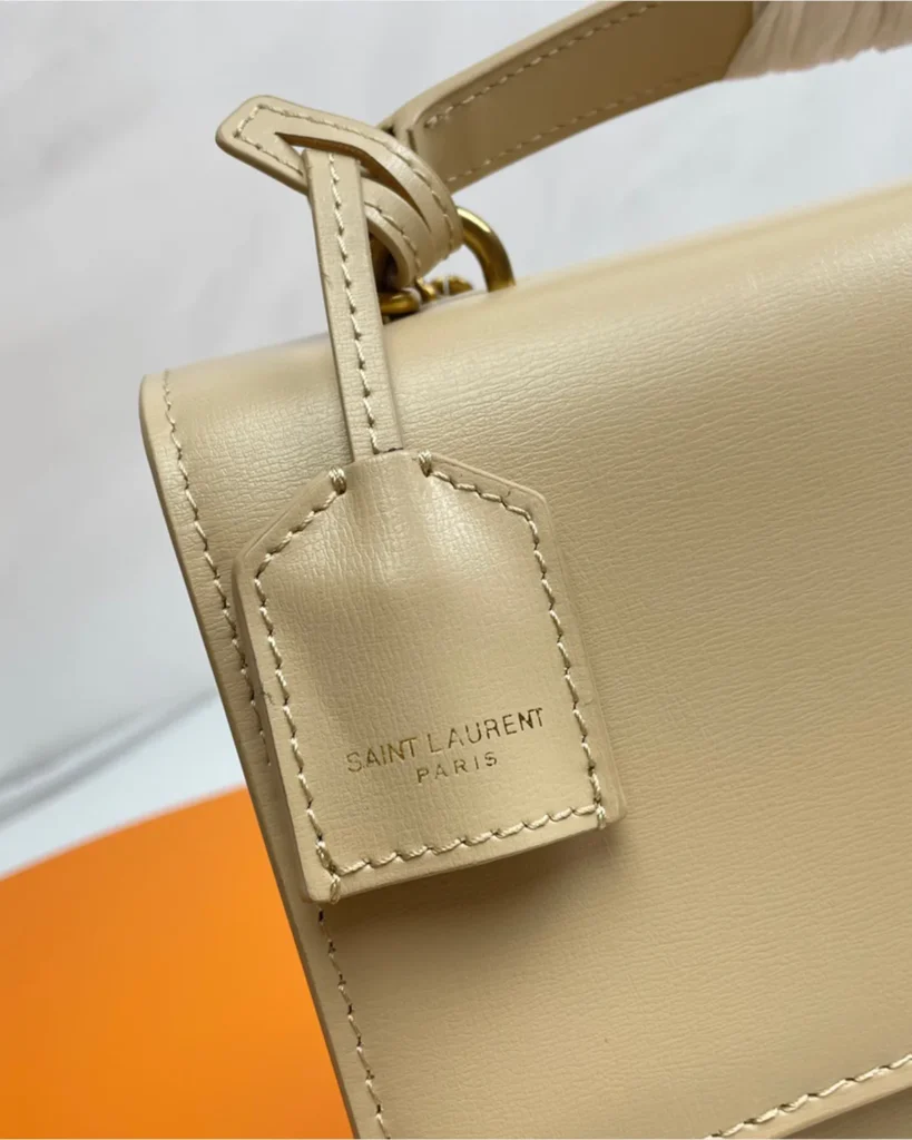 Cream Top-Handle Accordion Flap Bag — tag detail view