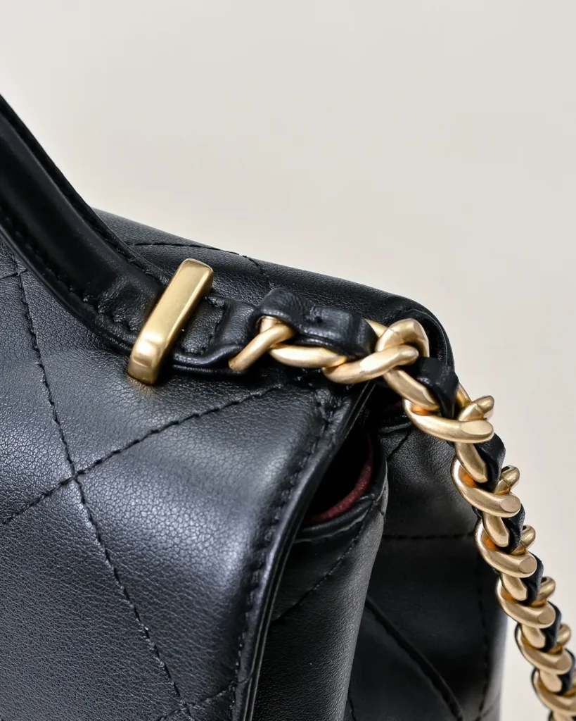 Black Quilted Top-Handle Flap Bag — handle detail view