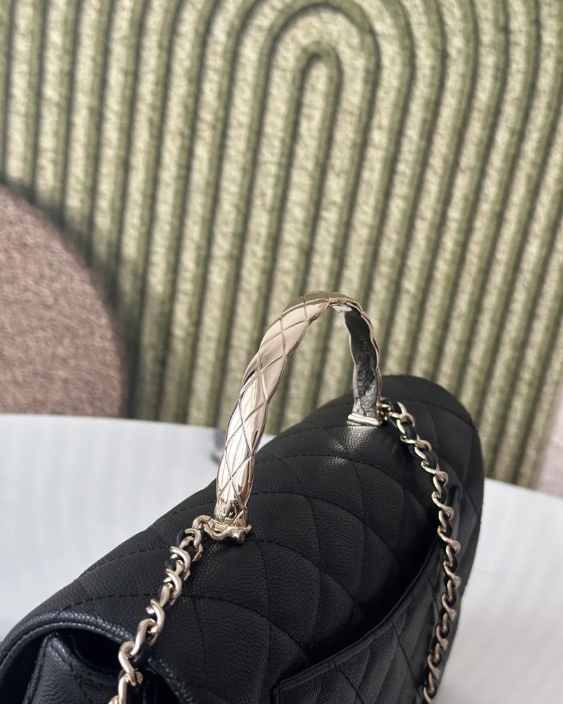 Black Quilted Metal-Handle Flap Bag — handle detail view