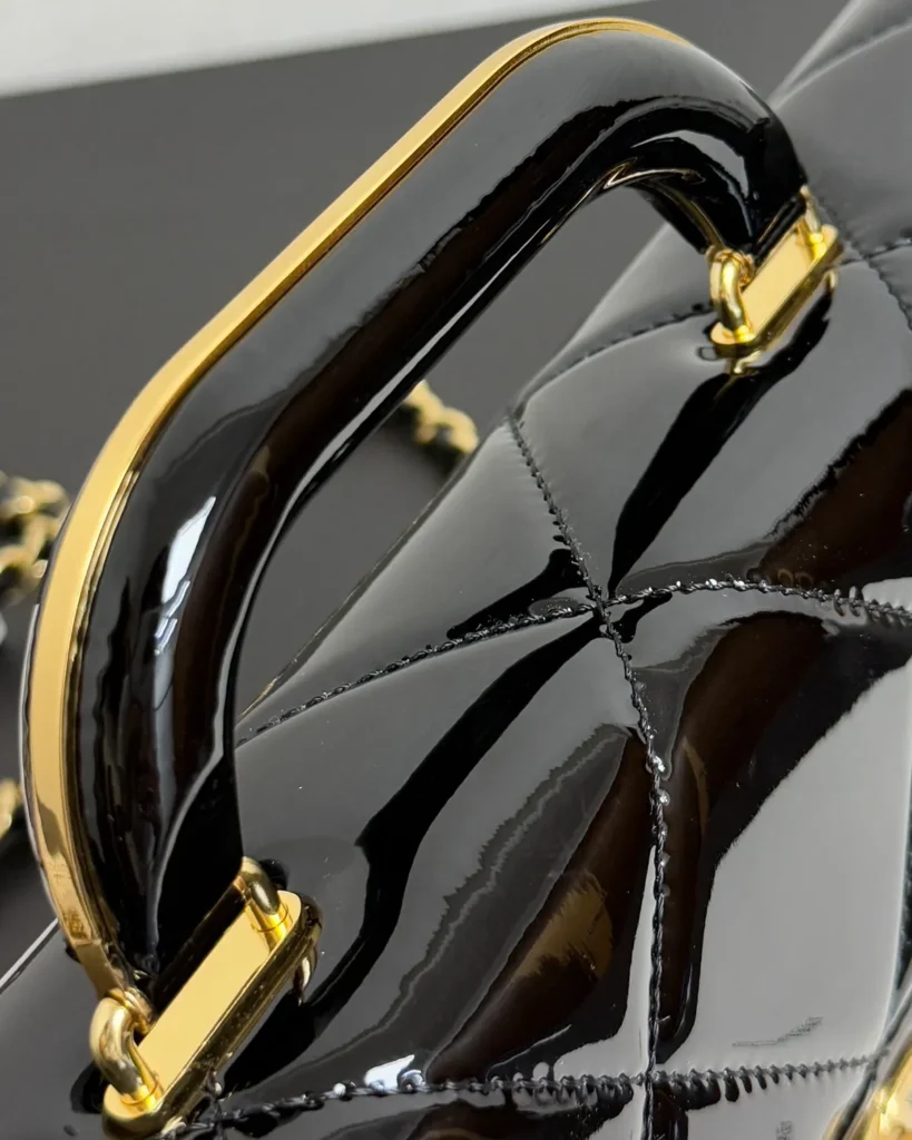 Glossy Black Quilted Handle Clutch — handle detail view