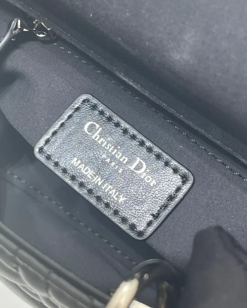 Black Quilted Top Handle Bag with Silver-Tone Charms — interior label view