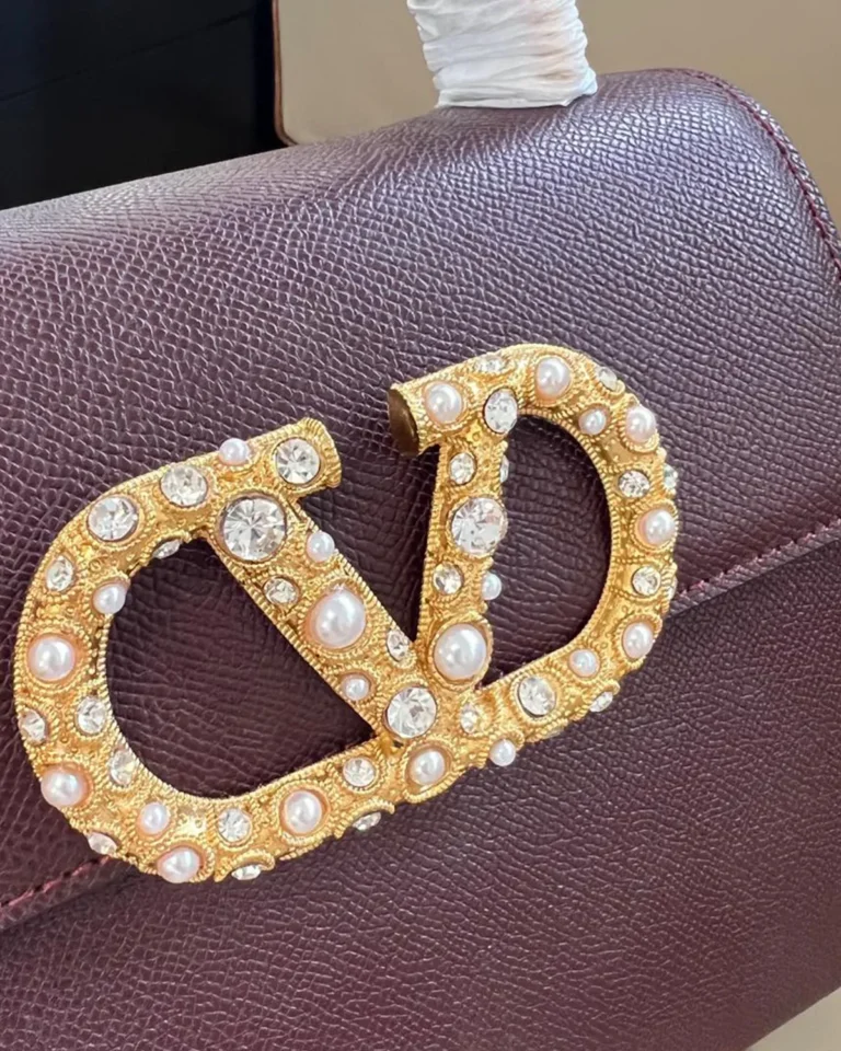 Burgundy Pearl-Effect Emblem Top-Handle Bag — emblem detail view