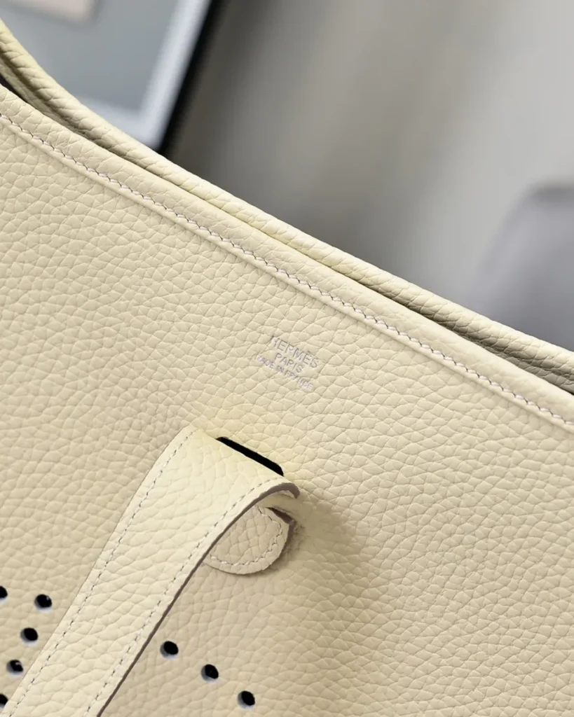 Evelyne-Inspired Ivory Perforated Shoulder Bag, fastening tab and surface grain