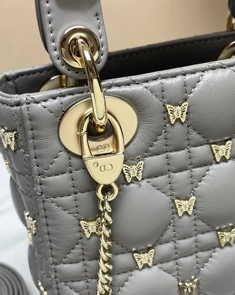 Gray Butterfly Stud Quilted Top Handle Bag — chain detail view