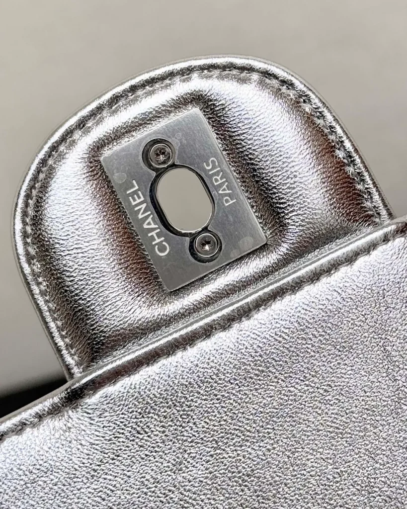 Metallic Silver Quilted Top-Handle Flap Bag — lock detail view