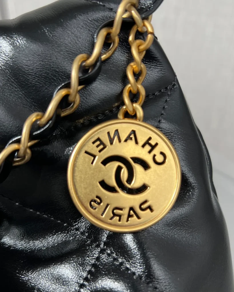 Glossy Black Quilted Chain Shopper — medallion detail view