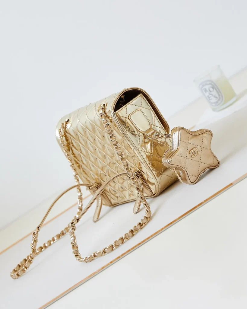 Metallic Gold Quilted Star-Charm Flap Bag — angled front view