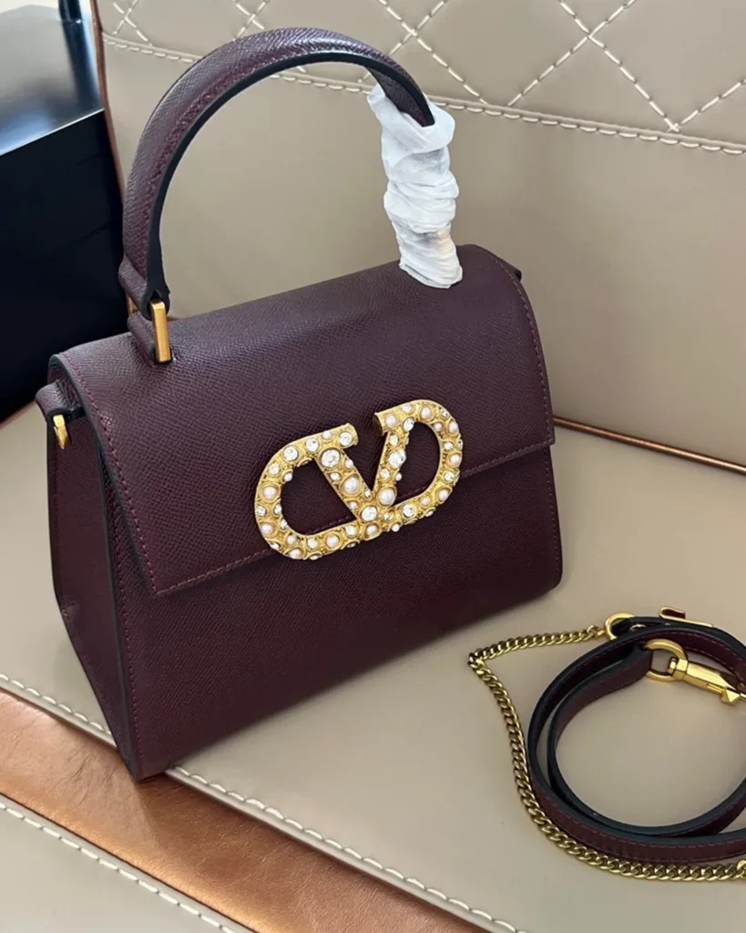 Burgundy Pearl-Effect Emblem Top-Handle Bag — angled front view