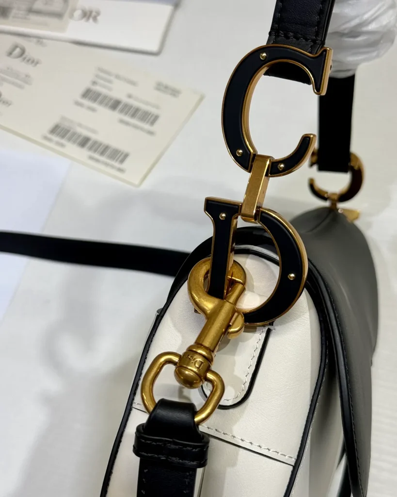 Cream and Black Asymmetric Saddle Bag — hardware detail view