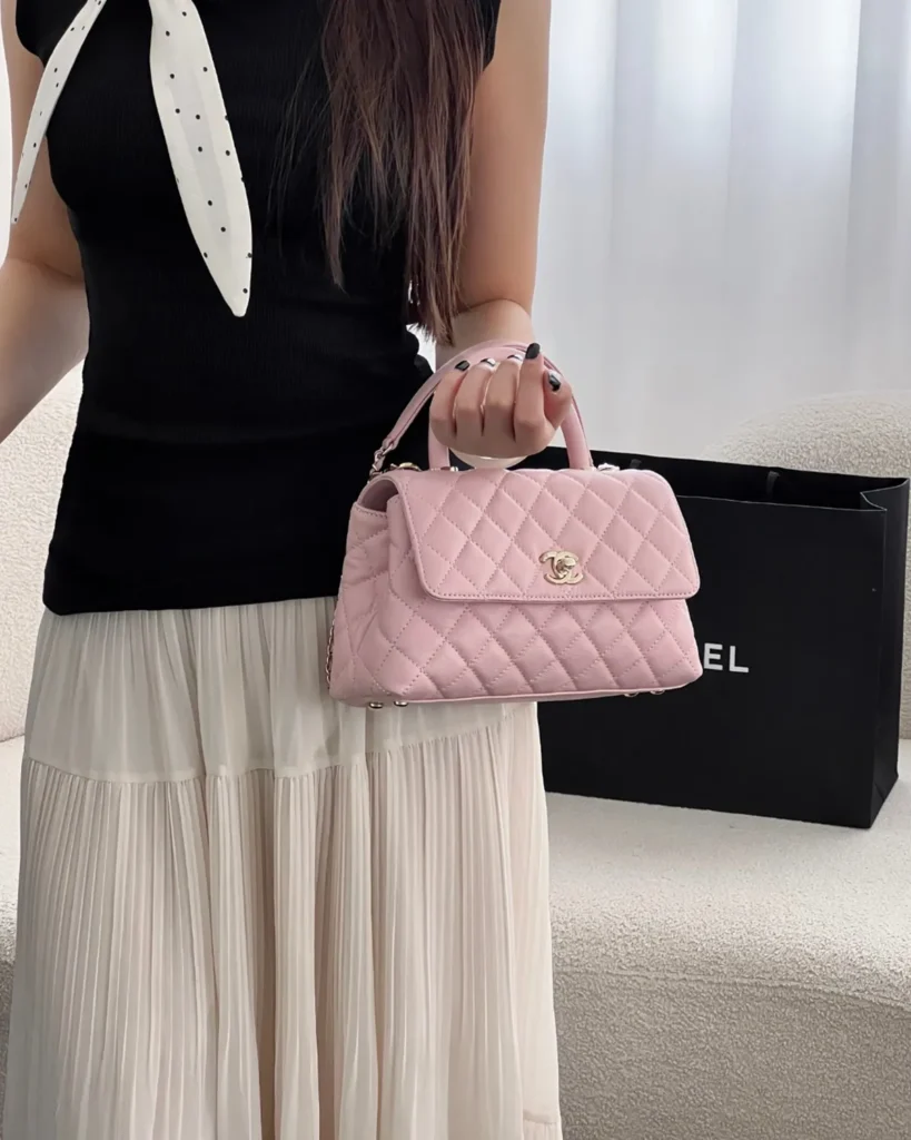 Light Pink Quilted Top-Handle Flap Bag — carried standing view