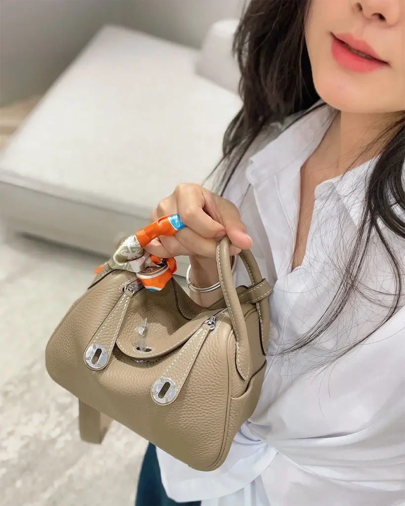 Lindy-Inspired Mini Taupe Crossbody Bag, carried view with long strap