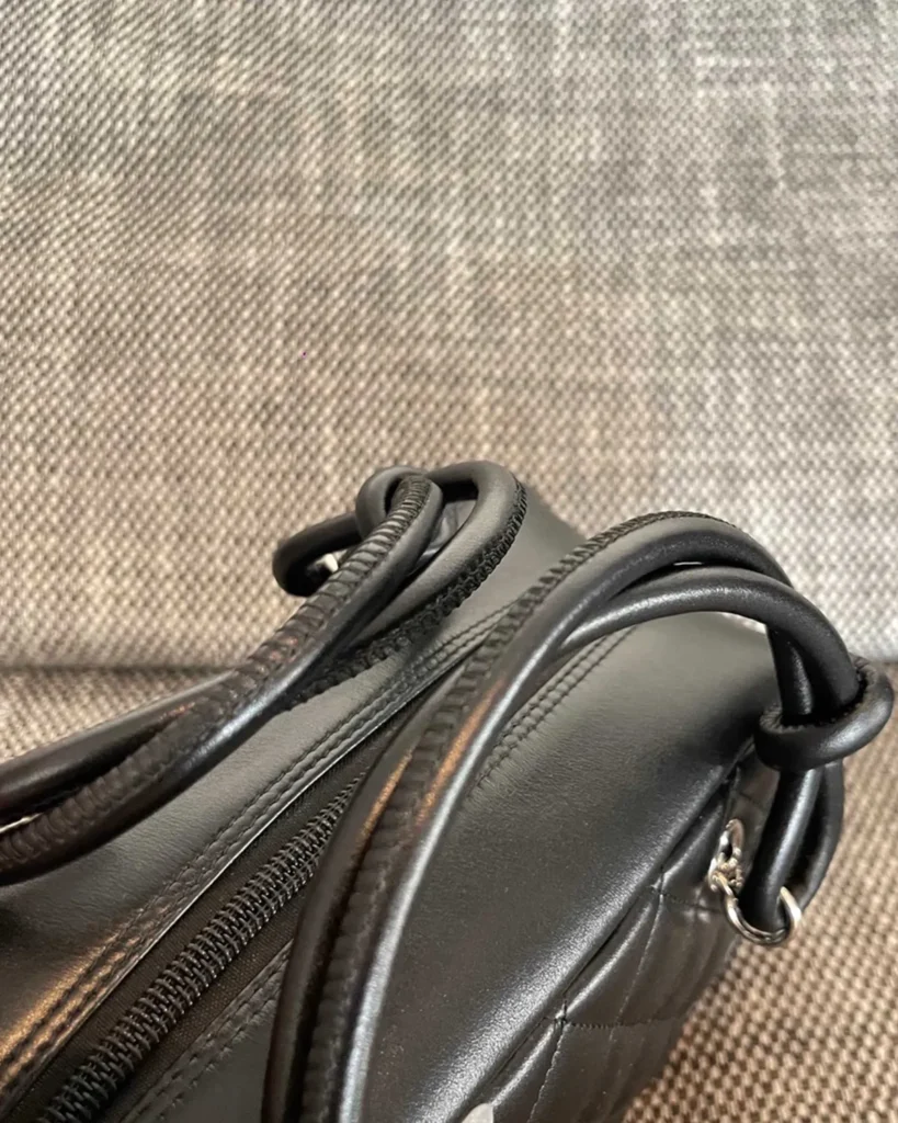 Black Quilted Offset-Emblem Bowler Bag — zipper detail view