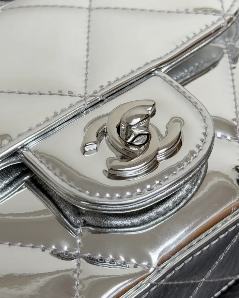 Metallic Silver Quilted Top-Handle Flap Bag — clasp detail view
