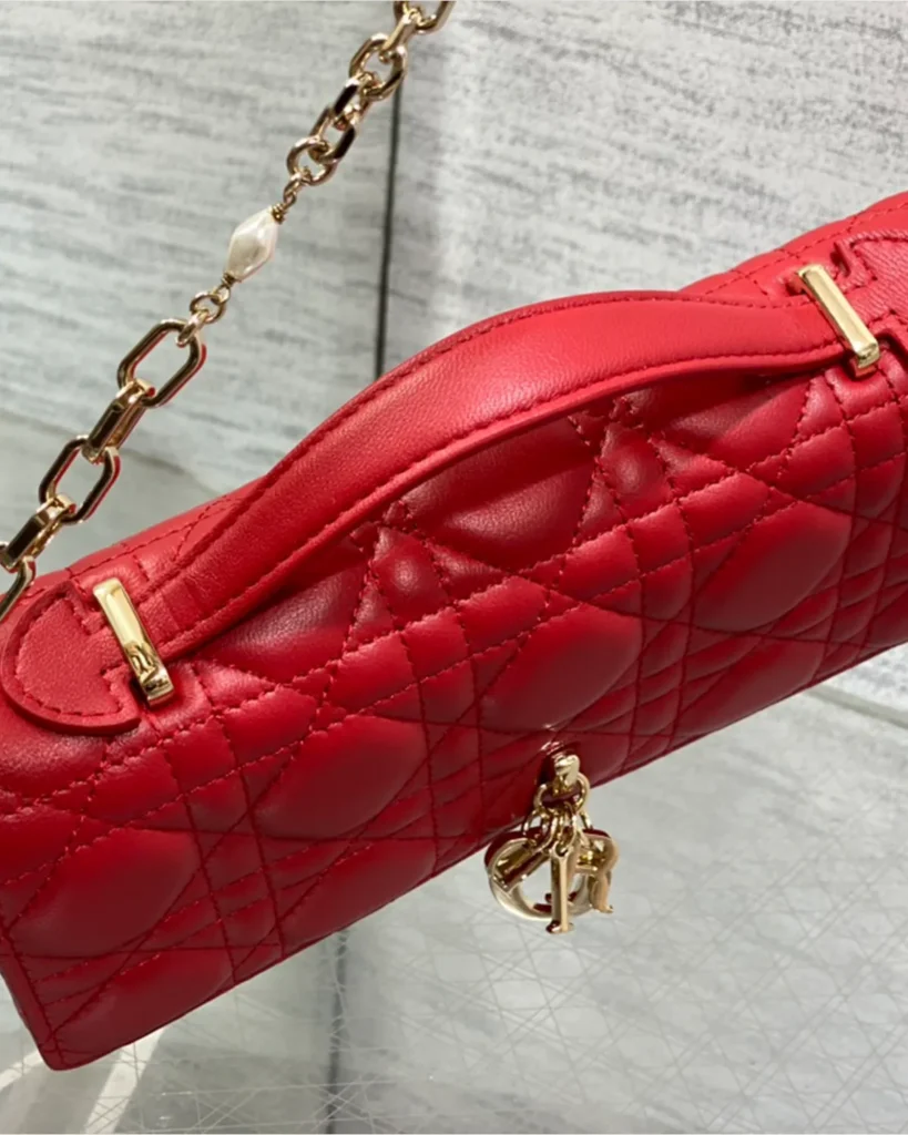 Red Quilted Top Handle Flap Bag — handle detail view