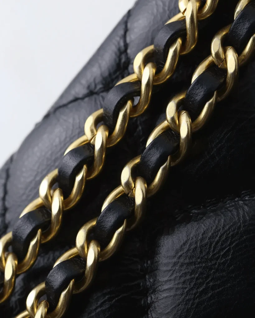 Black Quilted Tab-Flap Top-Handle Bag — chain detail view