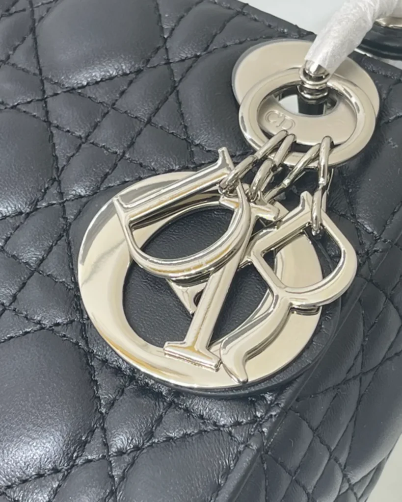 Black Quilted Top Handle Bag with Silver-Tone Charms — charm closeup view