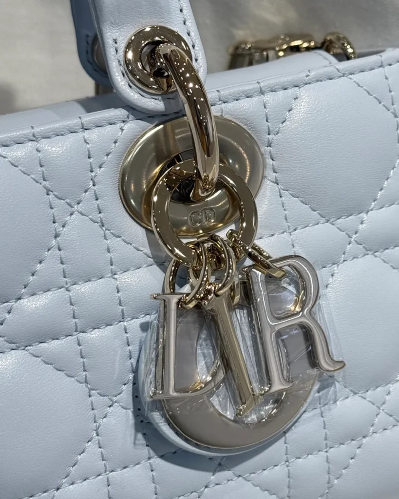 Pale Blue Horizontal Quilted Top Handle Bag — charm detail view