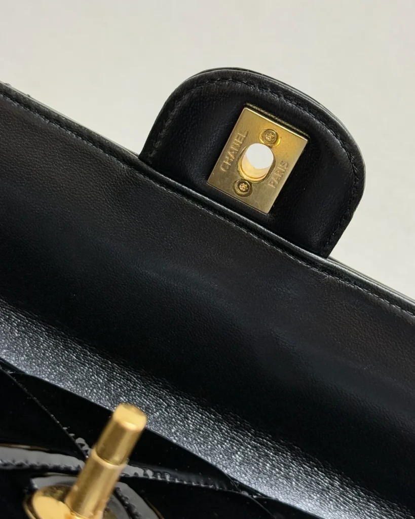 Glossy Black Quilted Handle Clutch — lock detail view