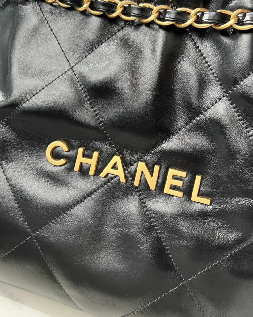 Glossy Black Quilted Chain Shopper — lettering detail view