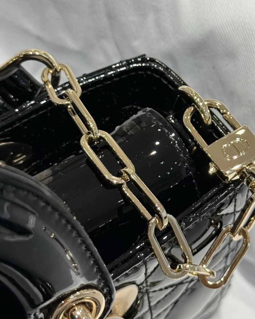 Glossy Black Horizontal Quilted Handbag — chain detail view