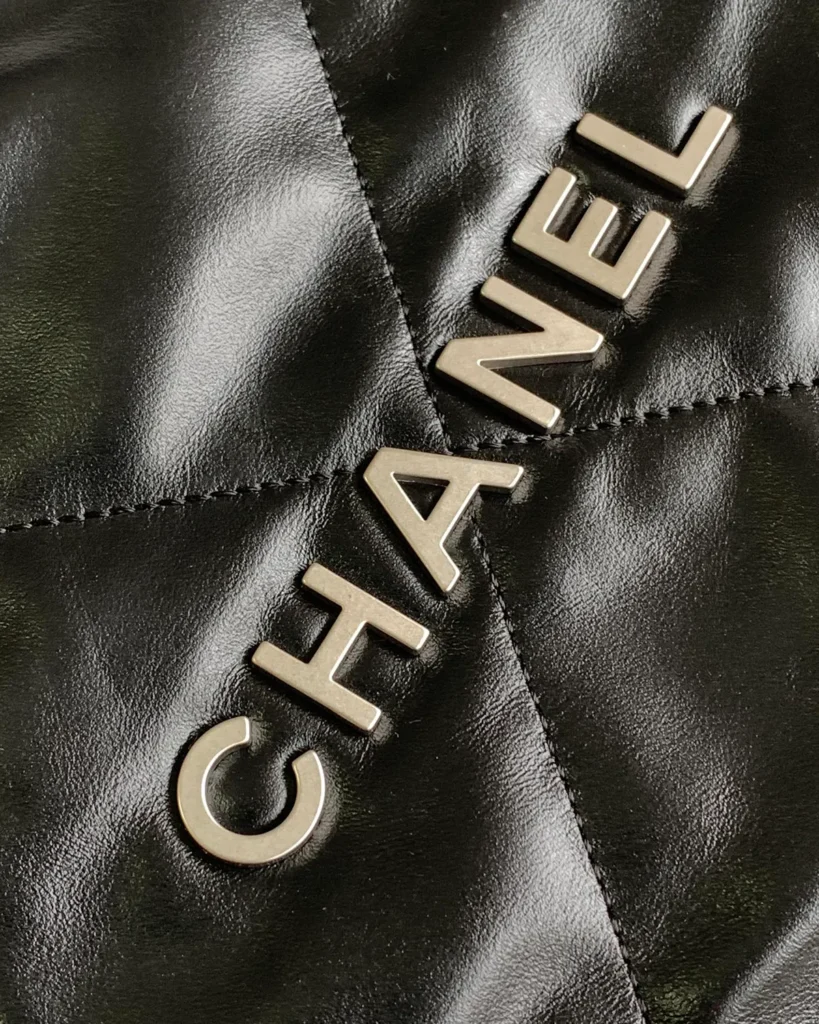 Glossy Black Quilted Gathered Tote — lettering detail view