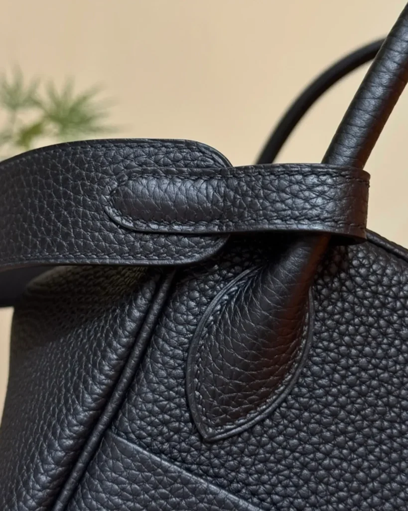 Black Folded Shoulder Bag with Gold-Tone Details — handle anchor view