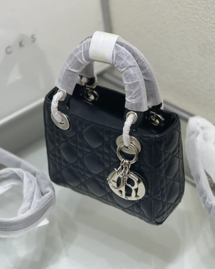 Black Quilted Top Handle Bag with Silver-Tone Charms — angled front view