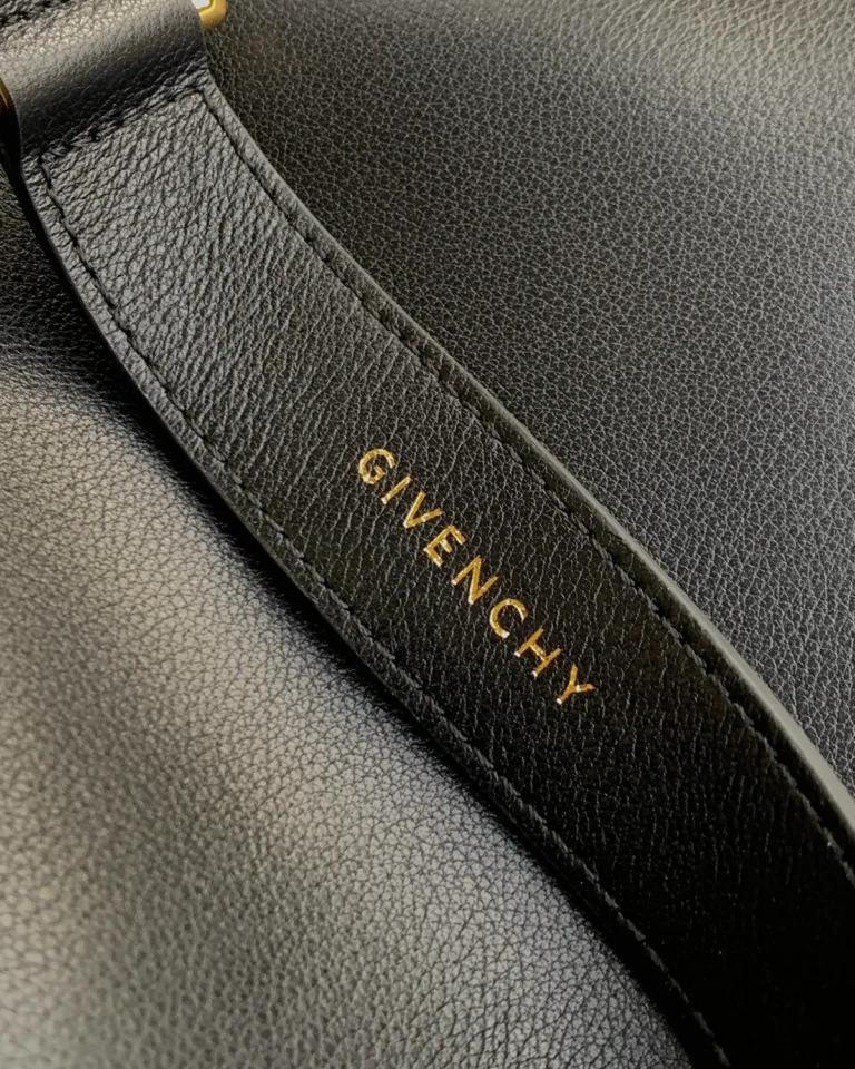 Black Curved-Top Buckle Shoulder Bag — strap lettering