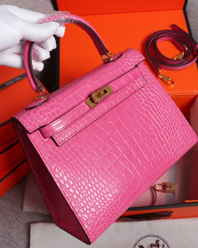 Kelly-Inspired Pink Croc-Pattern Top-Handle Bag, angled front held by handle