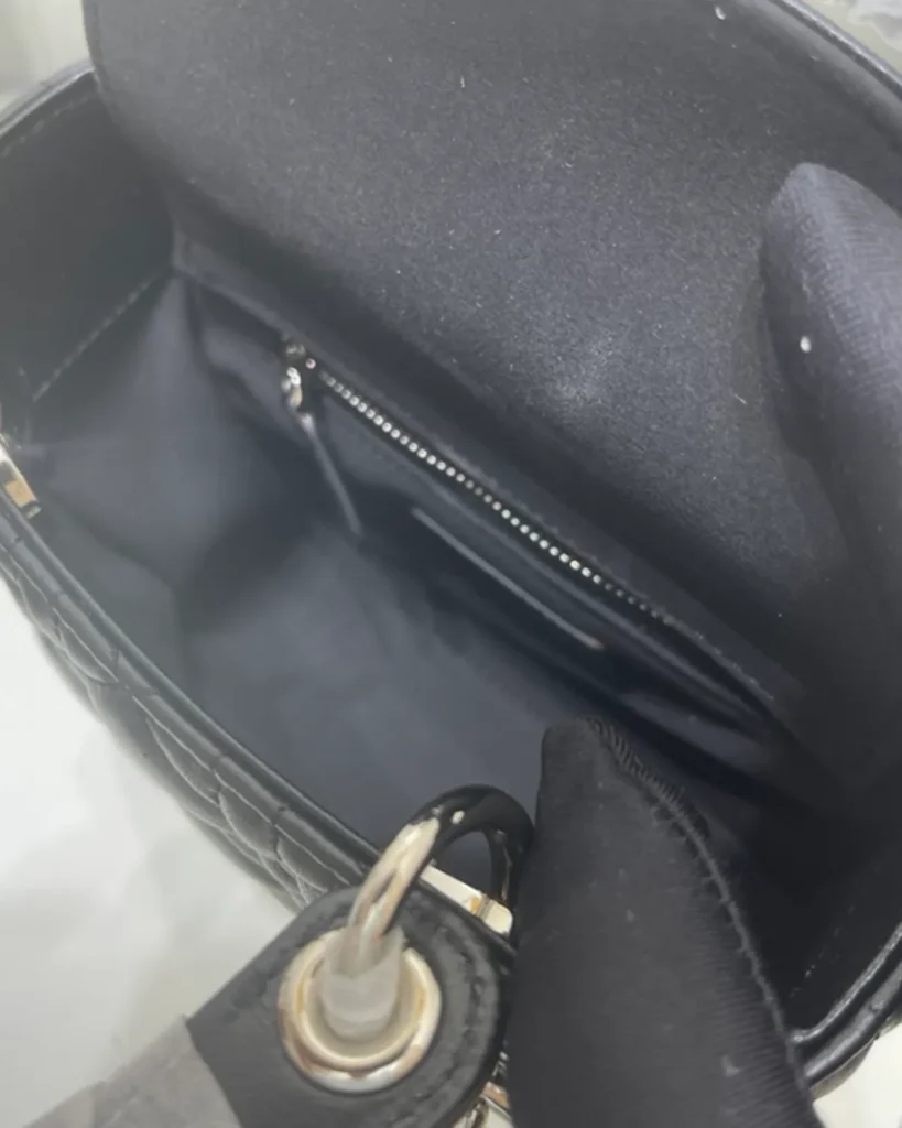 Black Quilted Top Handle Bag with Silver-Tone Charms — interior view