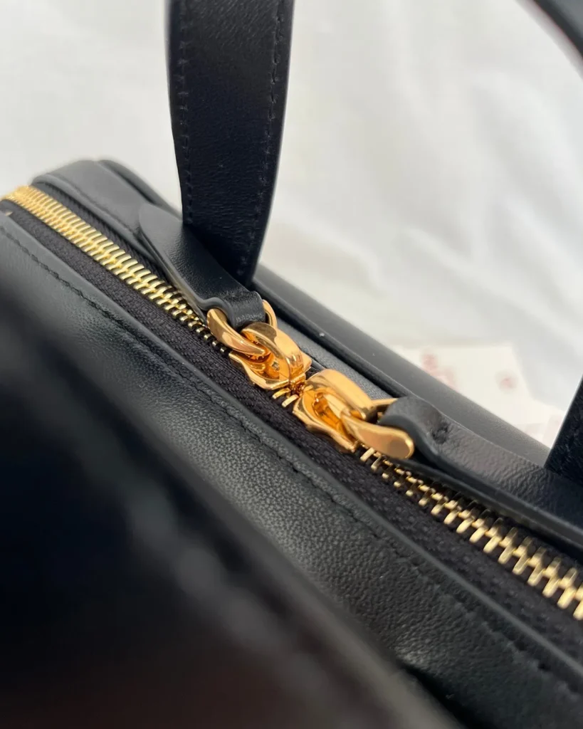 Black and Tan V-Panel Top-Handle Bag — zipper detail view
