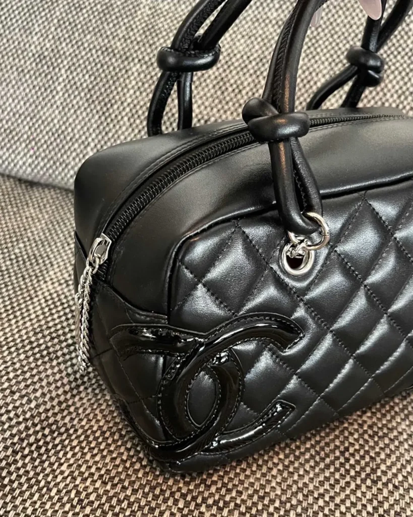 Black Quilted Offset-Emblem Bowler Bag — handle detail view