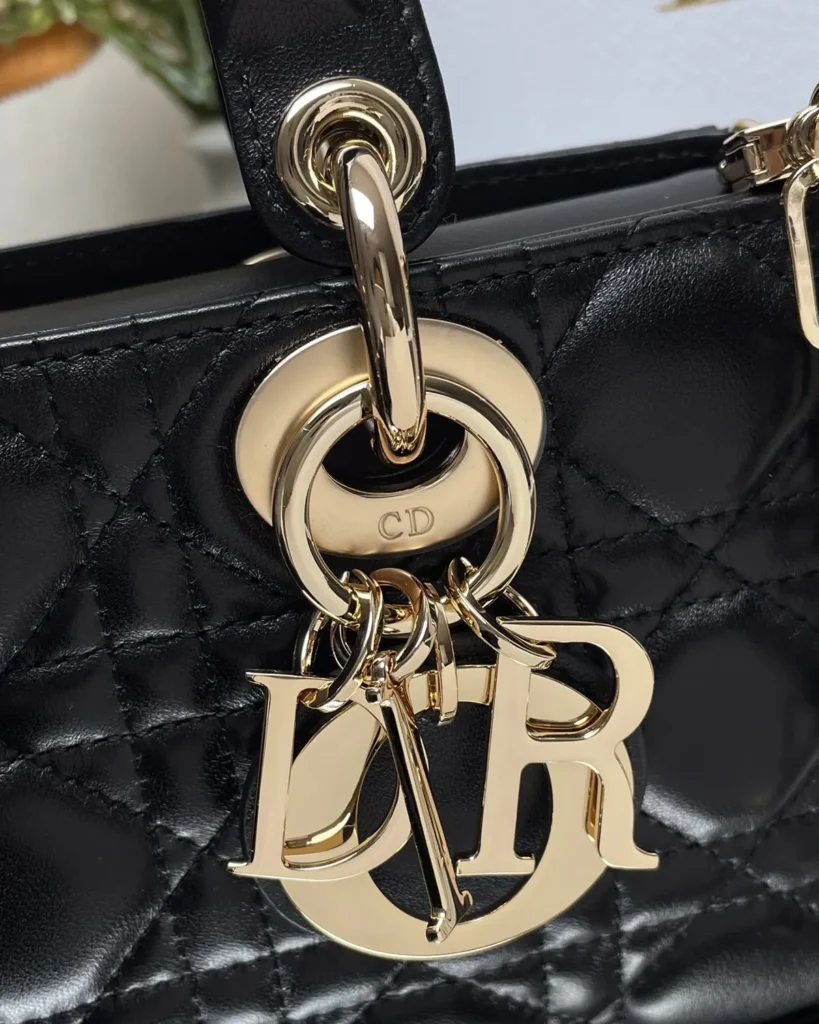 Black Quilted Chain Top Handle Bag — charm detail view