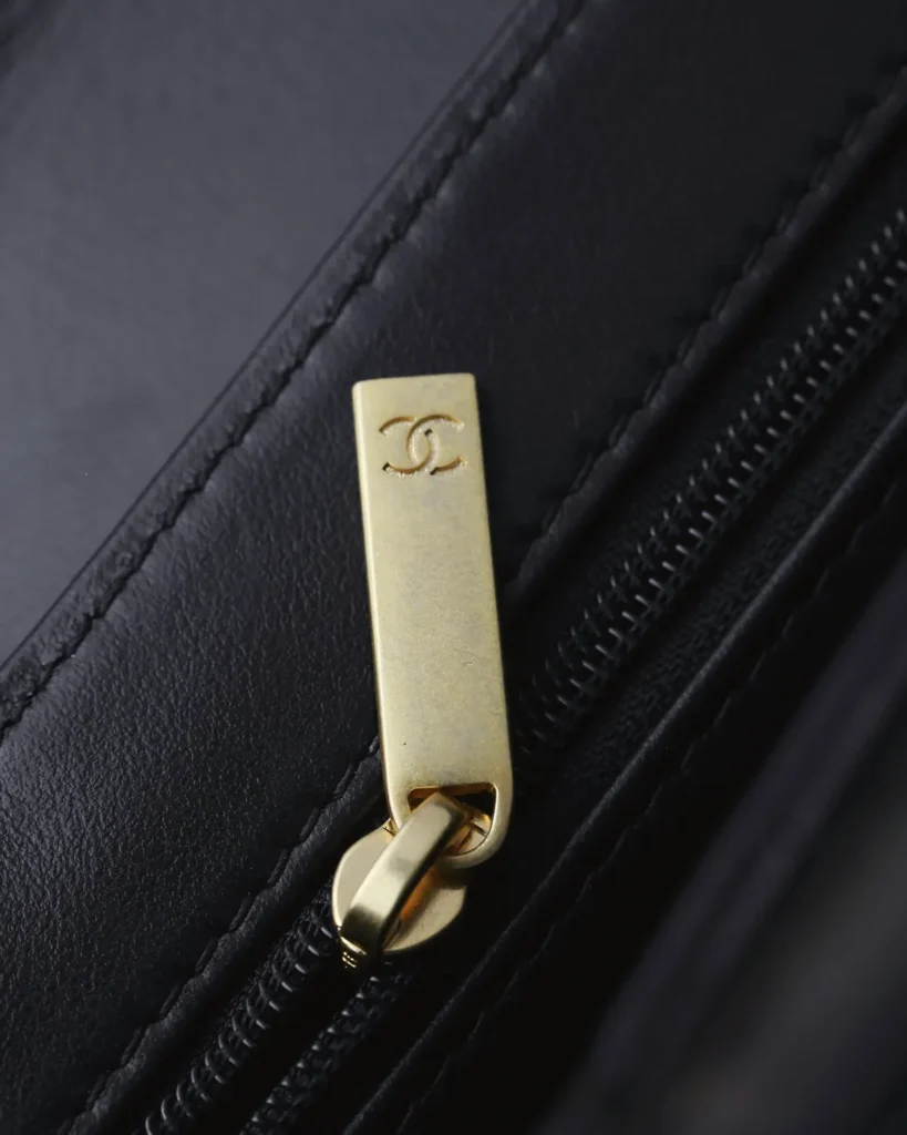 Black Quilted Tab-Flap Top-Handle Bag — zipper pull view