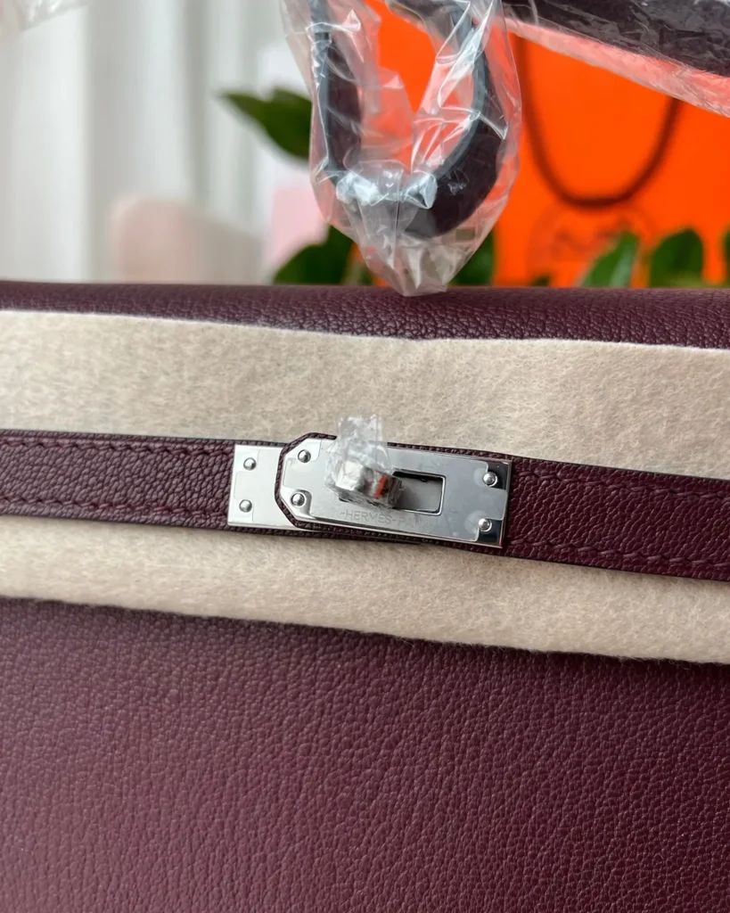Burgundy structured shoulder bag, clasp detail view