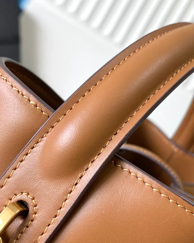Tan Curved-Top Bucket Bag — handle detail view
