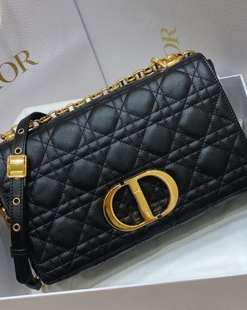 Black Quilted Flap Bag with Gold Tone Clasp — angled front view