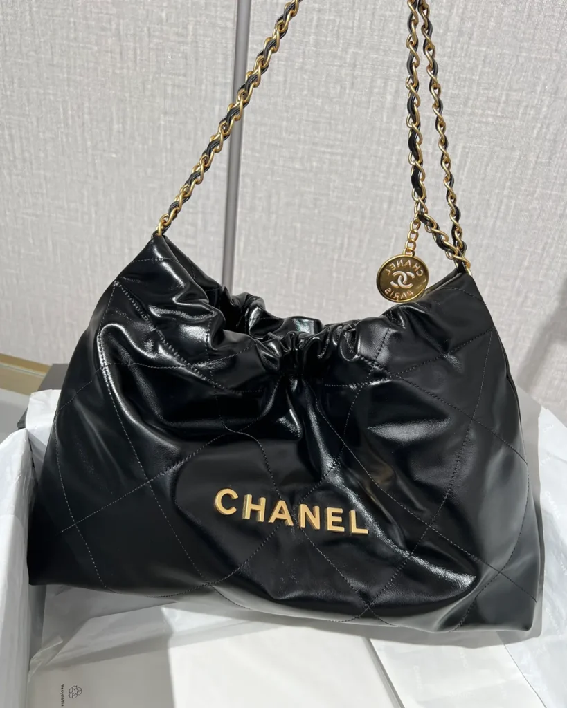 Glossy Black Quilted Chain Shopper — held front view