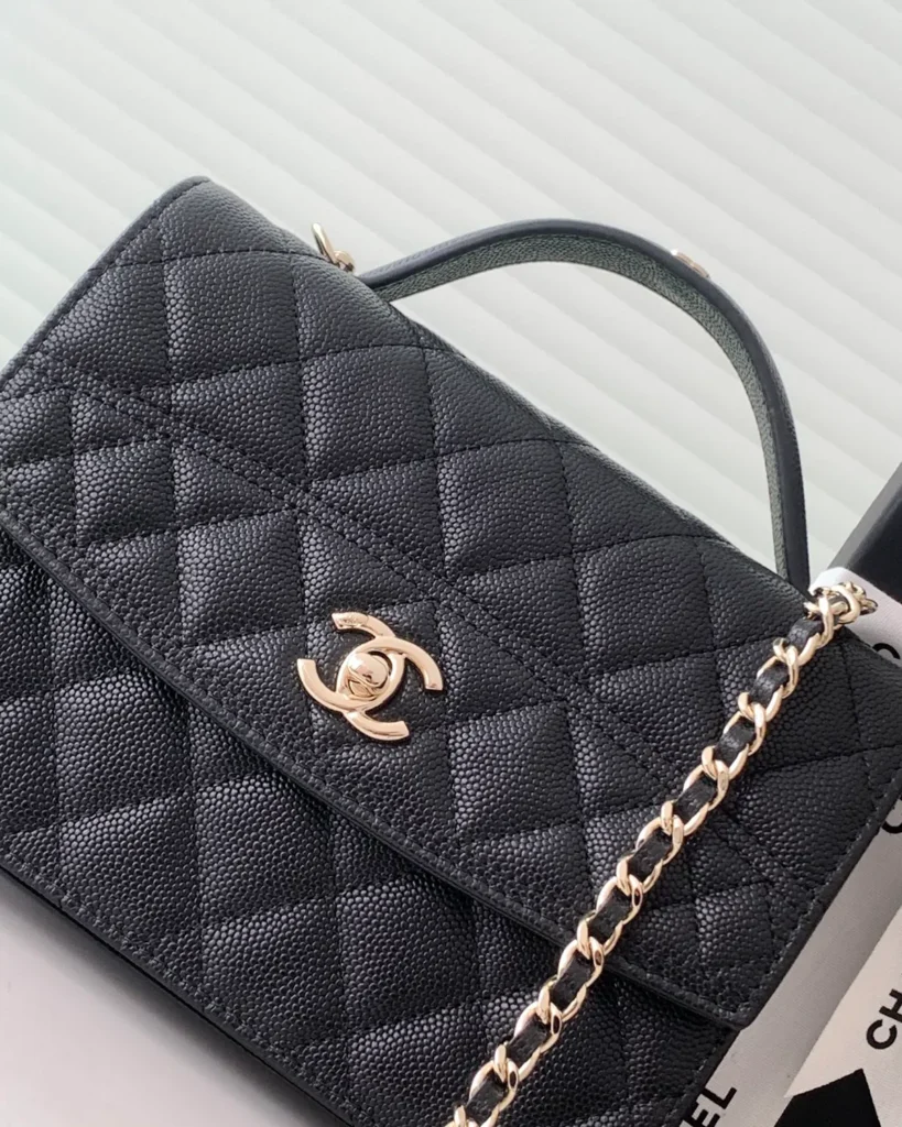 Black Quilted Top-Handle Chain Clutch — logo detail view