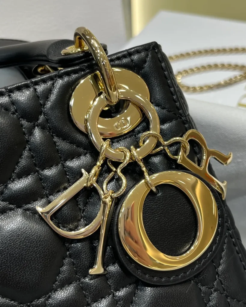 Black Quilted Chain Top Handle Bag — charm detail view