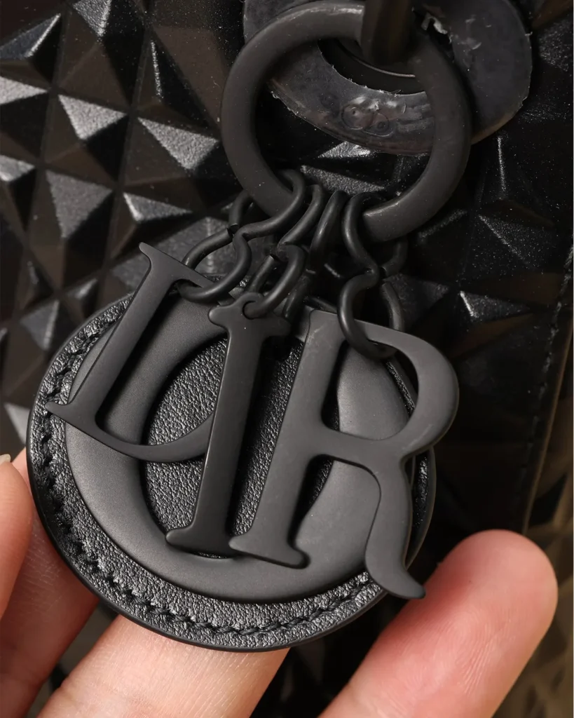 Black Faceted Top Handle Bag — charm detail view