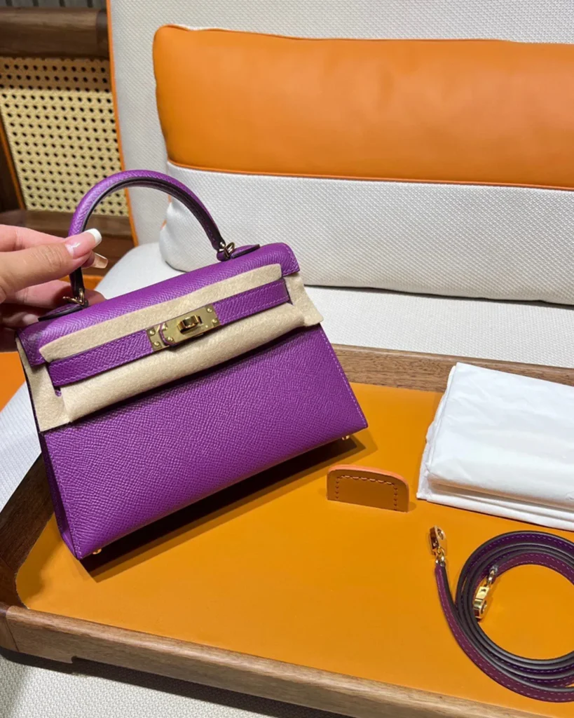 Kelly-Inspired Mini Anemone Purple Top-Handle Bag, angled front in packaging