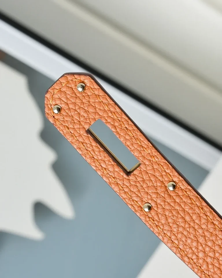 Kelly-Inspired 28 Orange Structured Top-Handle Bag, fastening strap end